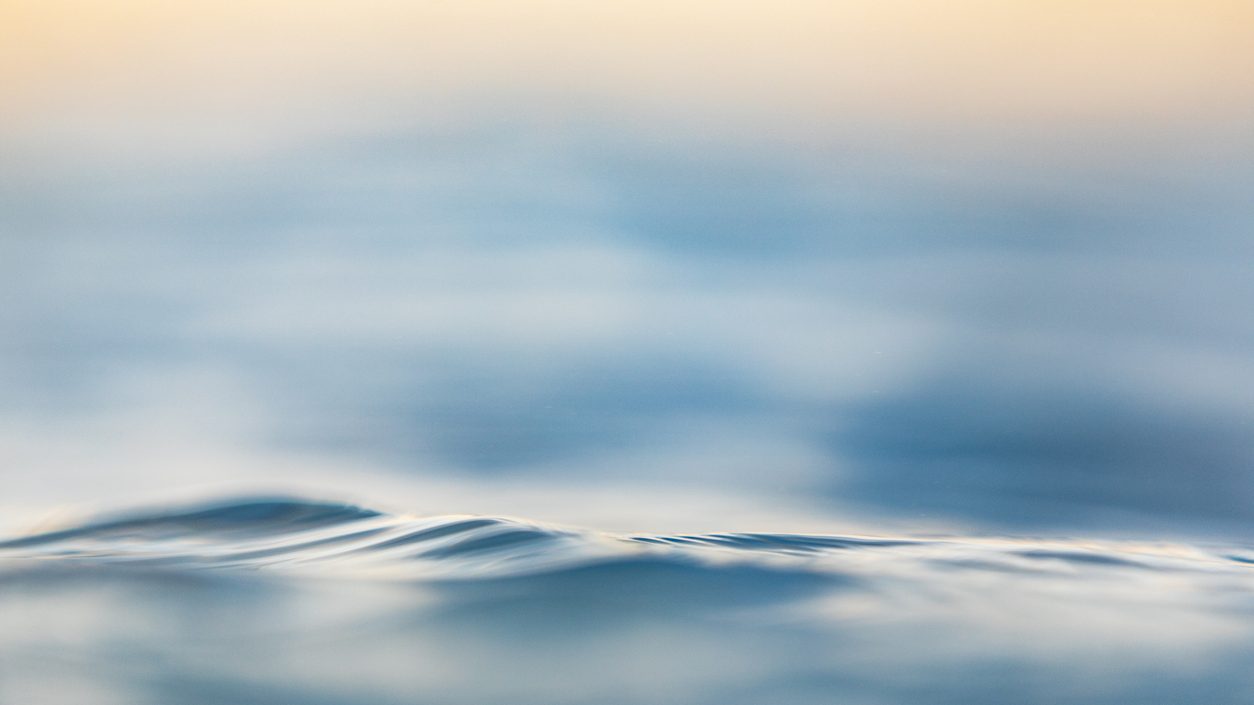 Sanfte Wellen im warmen Licht als Sinnbild für Ruhe und Entspannung im Wasser